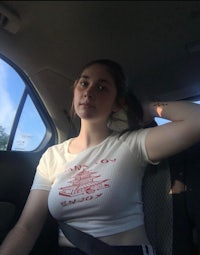 a girl sitting in the back seat of a car