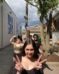 a group of girls posing for a photo on a sidewalk